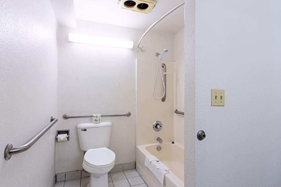 Mobility-accessible bathroom with grab bars and bathtub