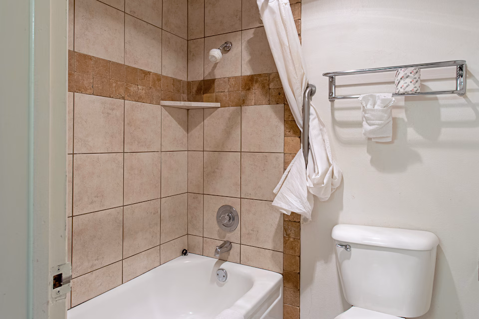 Guest bathroom with tiled bathtub and shower
