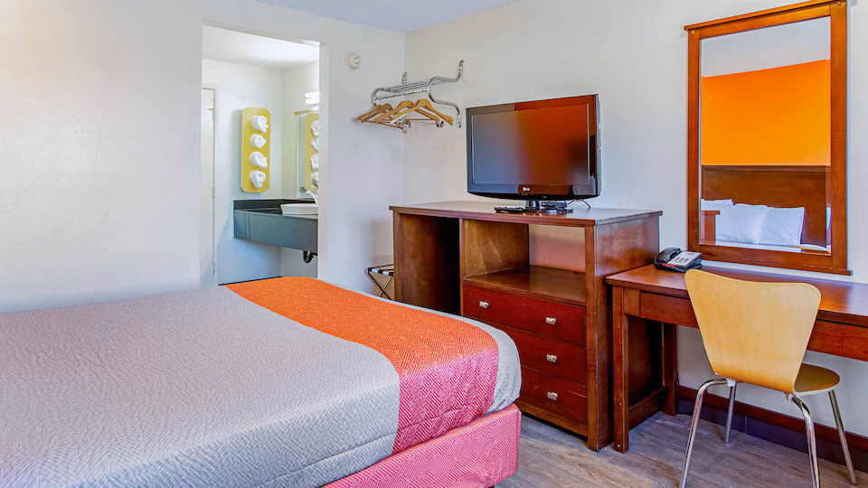 Queen guest room with television and work desk
